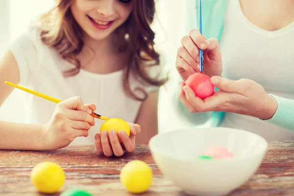 Primo piano di bambina e madre che colorano le uova — Foto Stock