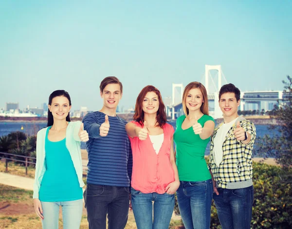 Groep lachende studenten tonen duimen omhoog — Stockfoto