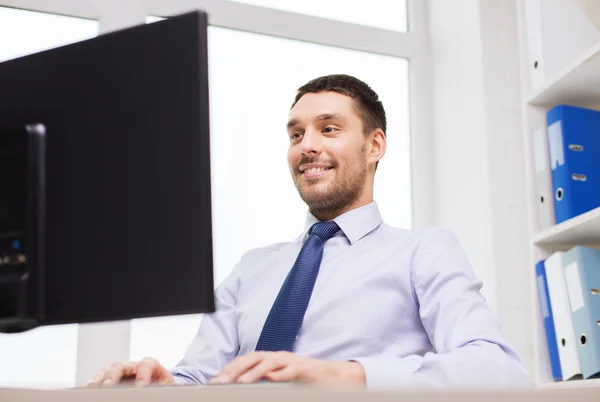 Sonriente hombre de negocios con computadora en la oficina —  Fotos de Stock