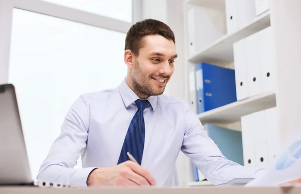 Homme d'affaires avec ordinateur portable et papiers au bureau — Photo