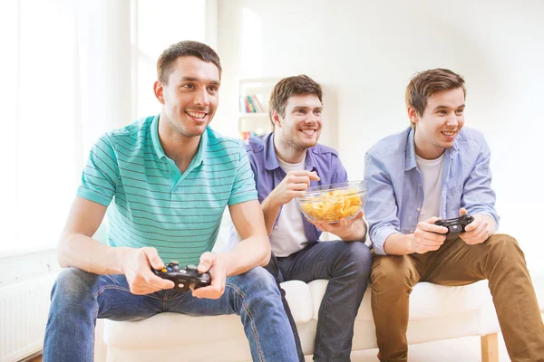 Lachende vrienden spelen van videospellen thuis — Stockfoto