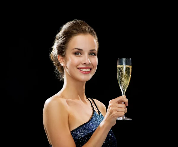 Sonriente mujer sosteniendo un vaso de vino espumoso —  Fotos de Stock