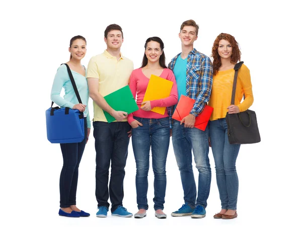 Gruppo di adolescenti sorridenti con cartelle e borse — Foto Stock