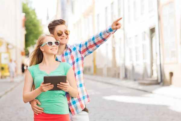 Lachende paar met de tablet pc in stad — Stockfoto