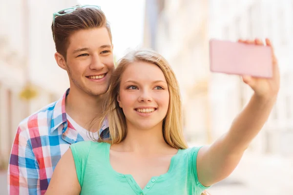 Casal sorridente com smartphone na cidade — Fotografia de Stock