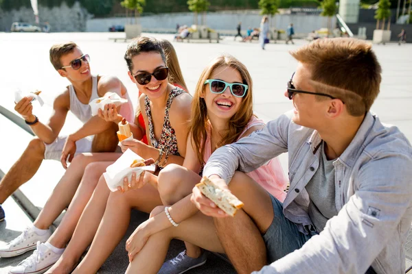 Grupp leende vänner sitter på torget — Stockfoto