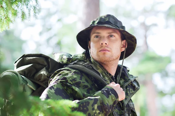 Joven soldado con mochila en el bosque — Foto de Stock