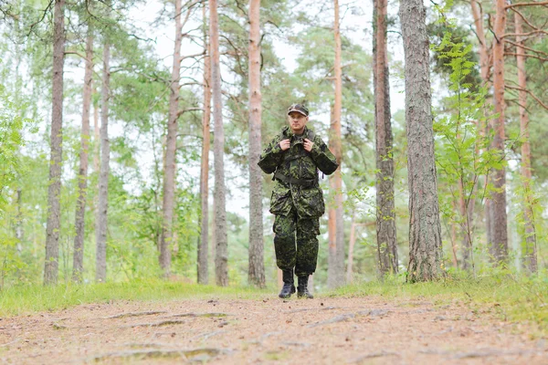 Young soldier with backpack in forest — Stock Photo, Image