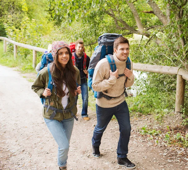 Grupo de amigos sorridentes com mochilas caminhadas — Fotografia de Stock