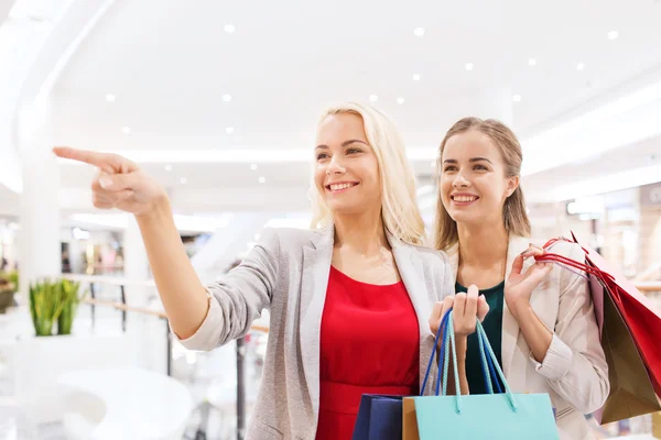 Heureux jeunes femmes avec des sacs à provisions dans le centre commercial — Photo