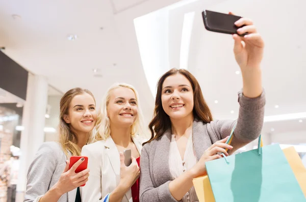 Women with smartphones shopping and taking selfie — Stock Photo, Image