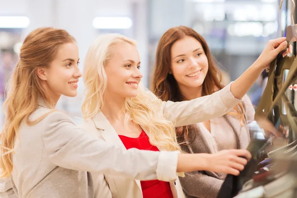 Mujeres jóvenes felices eligiendo ropa en el centro comercial — Foto de Stock