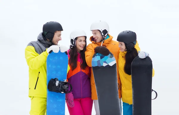 Happy friends in helmets with snowboards talking — Stock Photo, Image