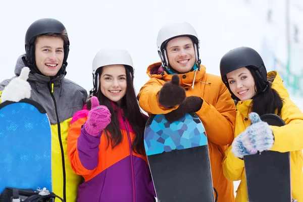 Gelukkige vrienden in helmen met snowboards — Stockfoto