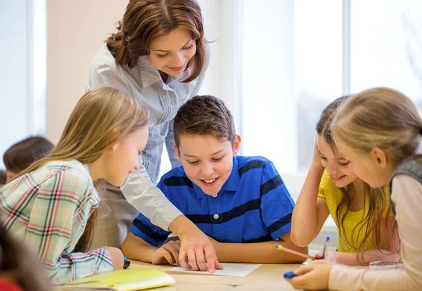 Groep van school-kids schrijven test in klas — Stockfoto