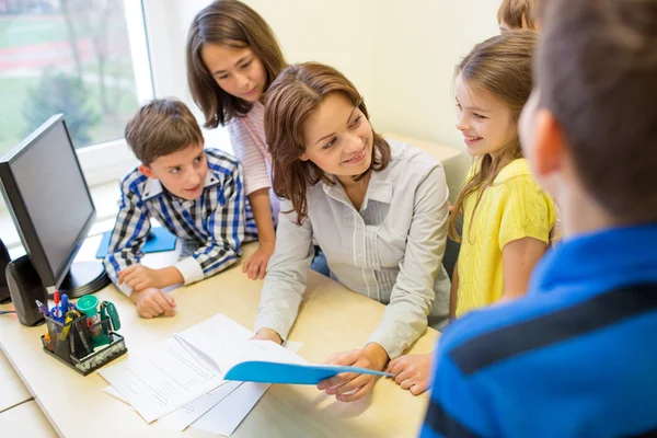 Group of school kids with teacher in classroom — Stock Photo, Image