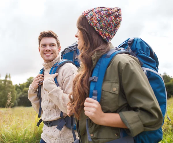 Lachende paar met rugzakken wandelen — Stockfoto