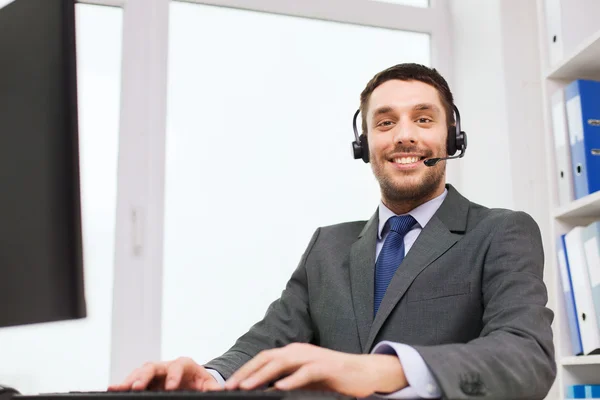 Homme d'affaires souriant avec ordinateur au bureau — Photo