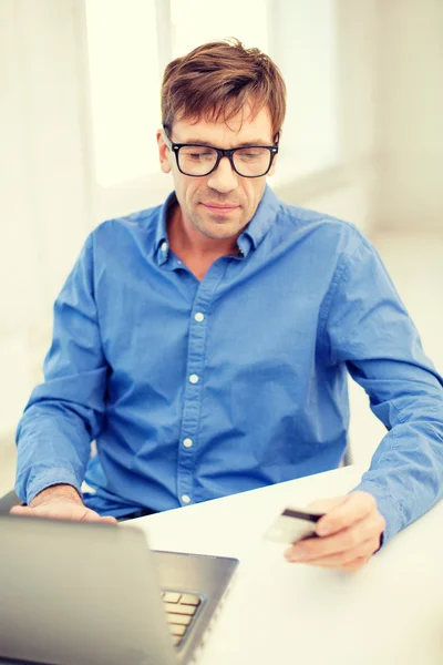 Man med laptop och kreditkort hemma — Stockfoto