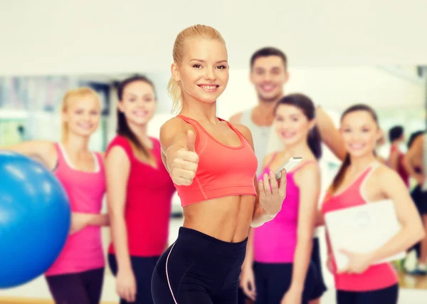 Lachende sportieve vrouw met smartphone — Stockfoto