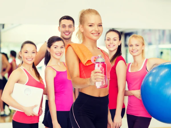 Lachende sportieve vrouw met fles water en handdoek — Stockfoto