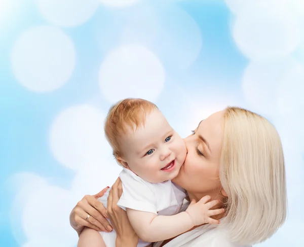Happy matka líbání usmívající se dítě — Stock fotografie