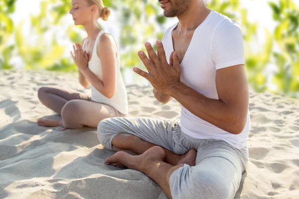 Lächelndes Paar macht Yoga-Übungen im Freien — Stockfoto