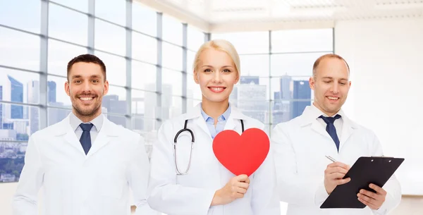 Jovens médicos cardiologistas felizes com coração vermelho — Fotografia de Stock