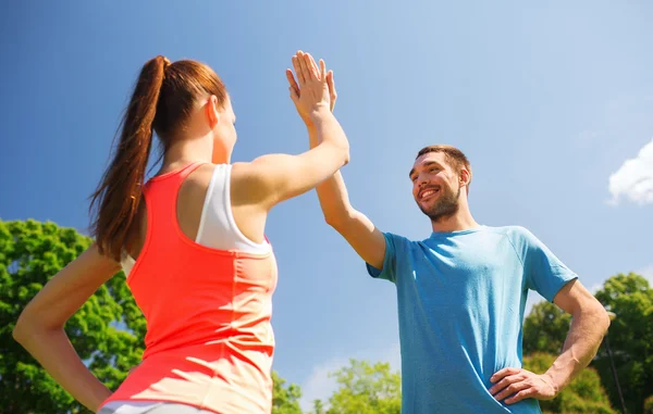Two smiling people making high five outdoors — Stock Photo, Image