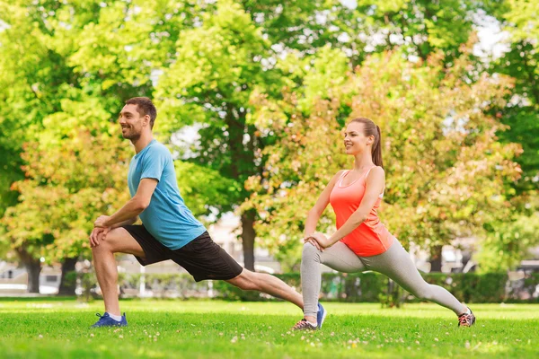 Smiling couple stretching outdoors — Stock Photo, Image