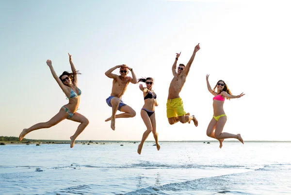 Amis souriants dans des lunettes de soleil sur la plage d'été — Photo