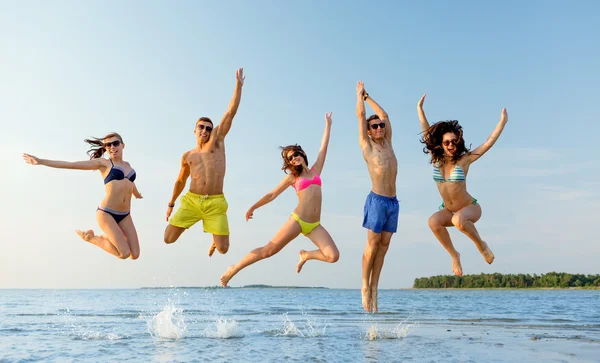 Amis souriants dans des lunettes de soleil sur la plage d'été — Photo