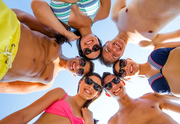 Lachende vrienden in cirkel op zomer strand — Stockfoto