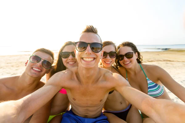 Grupo de amigos sorrindo fazendo selfie na praia — Fotografia de Stock