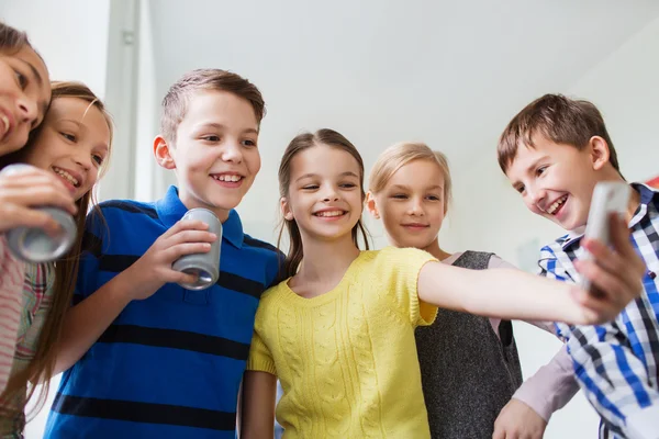 Grupp av skolbarnen med smartphone och soda burkar — Stockfoto