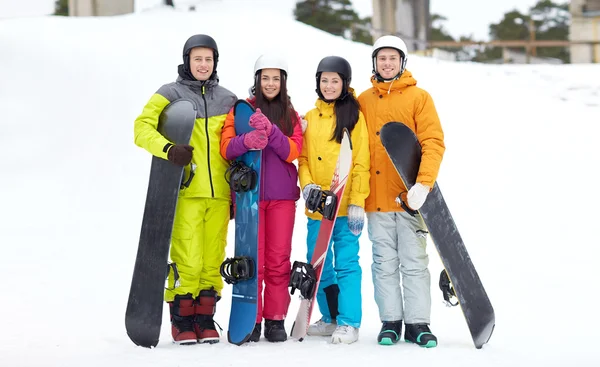 Happy friends in helmets with snowboards — Stock Photo, Image