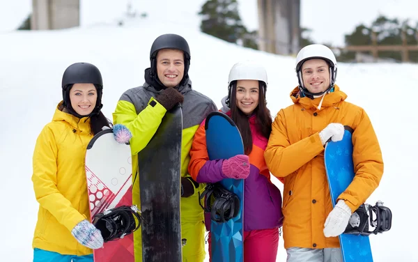Счастливые друзья в шлемах со сноубордами — стоковое фото