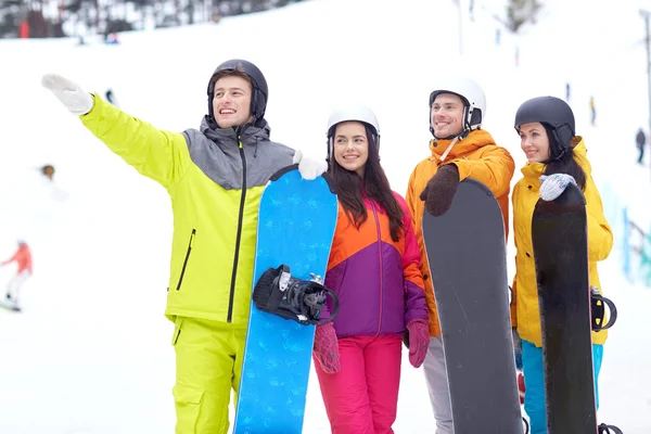 Happy friends in helmets with snowboards — Stock Photo, Image