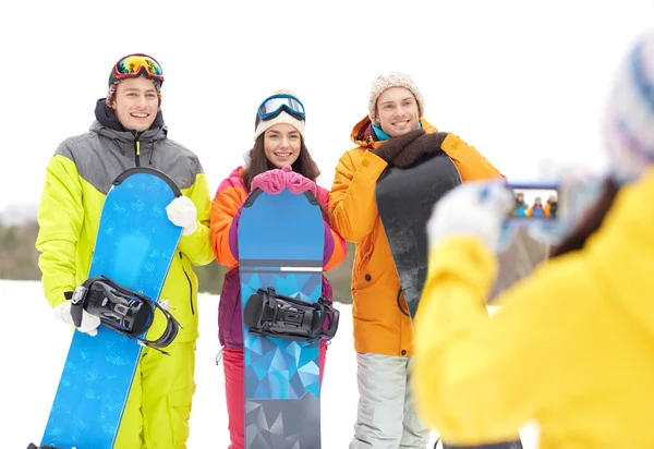 Happy friends with snowboards and smartphone — Stock Photo, Image