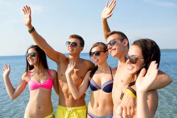 Amigos sonrientes en gafas de sol en la playa de verano —  Fotos de Stock