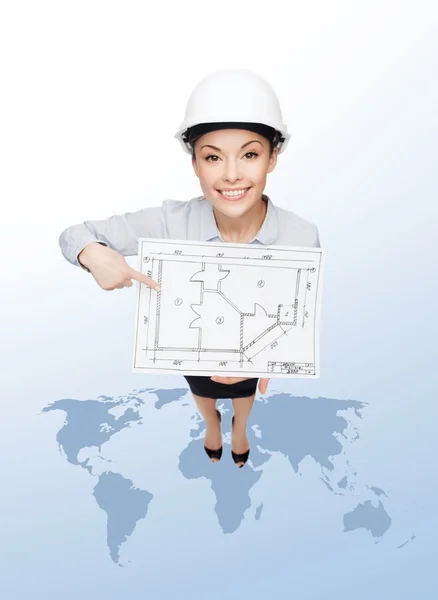 Businesswoman in helmet showing with blueprint — Stock Photo, Image