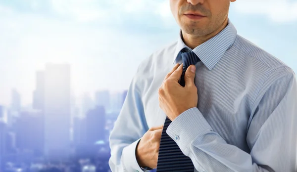 Close up of man in shirt adjusting tie on neck — Stock Photo, Image