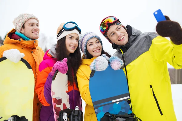 Amis heureux avec snowboards et smartphone — Photo