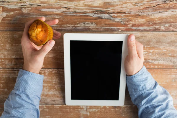 Primo piano delle mani maschili con tablet pc e muffin — Foto Stock