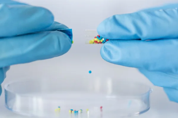 Primer plano de manos científicas sosteniendo píldora en el laboratorio — Foto de Stock