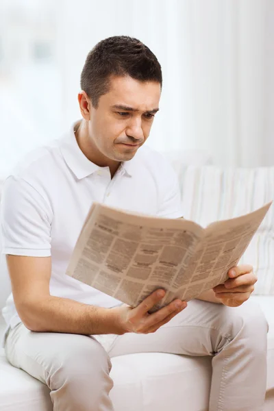 Triste hombre leyendo el periódico en casa — Foto de Stock