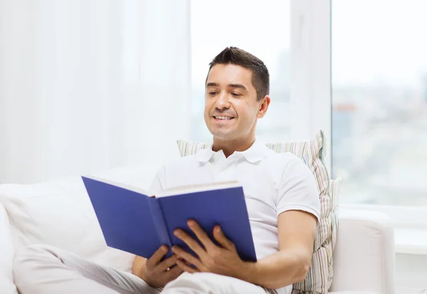 Homem feliz lendo livro em casa — Fotografia de Stock
