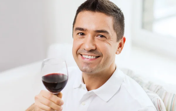 Hombre feliz beber vino tinto de vidrio en casa — Foto de Stock