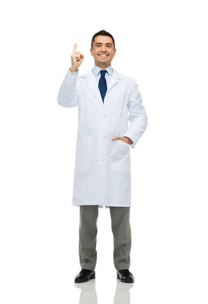 Uśmiechający się lekarza w biały płaszcz palcem wskazującym w górę — Zdjęcie stockowe