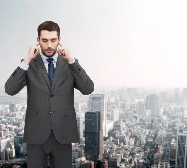 Annoyed businessman covering ears with his hands — Stock Photo, Image